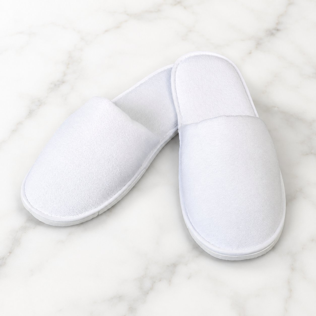 White 7mm closed toe disposable spa slippers on a light marble background for salon, spa, hotel, and treatment room use.
